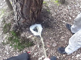 boys pissing together a big foamy puddle at a tree